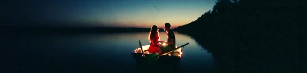 A couple in a rowboat, illuminated by glowing lights, journeying together across a vast ocean, symbolizing their decision to commit to a shared voyage of love and trust.