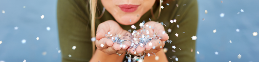 Woman blowing sparkle stars symbolizing letting go and surrender for personal growth and magic